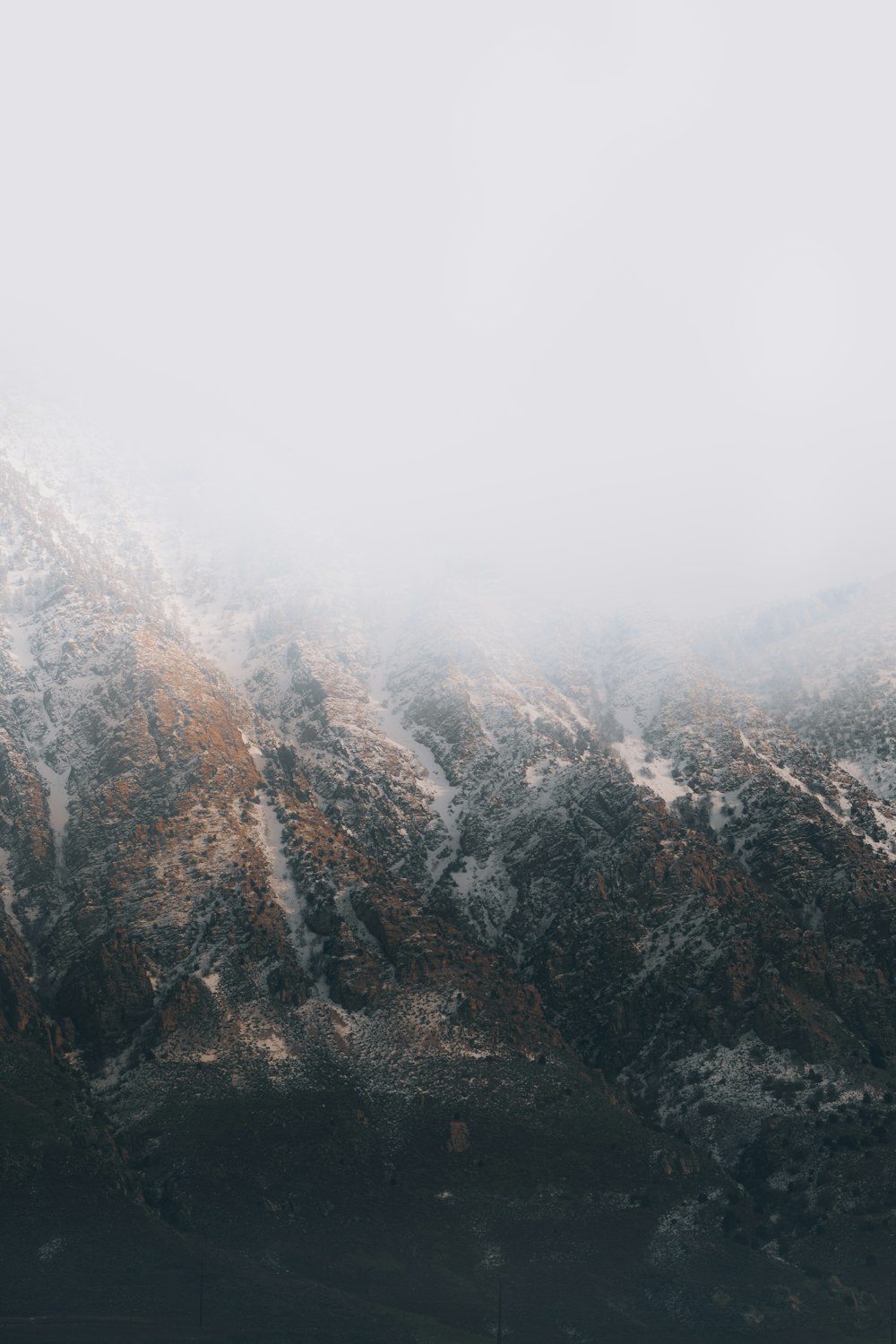 gray and brown mountain covered with fog