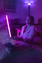 woman in white robe sitting and playing a video game