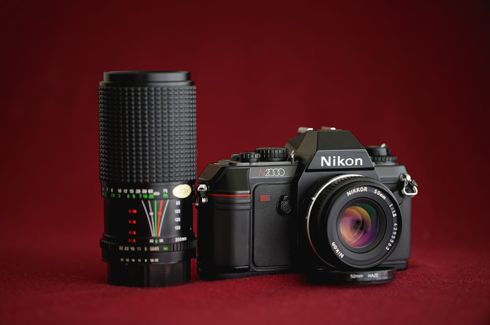 Cámara DSLR Nikon negra sobre textil rojo