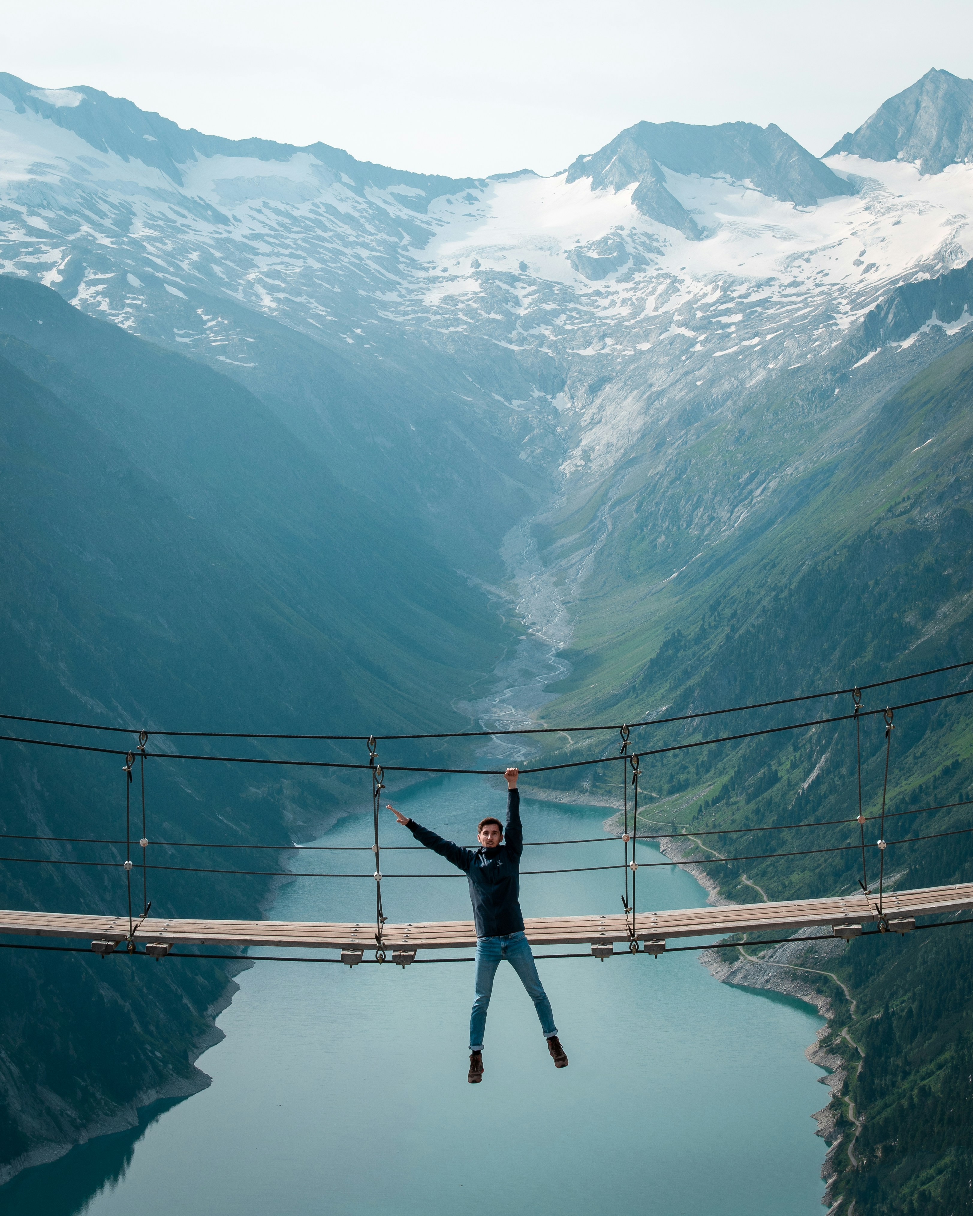 man in black jacket standing on bridge during daytime