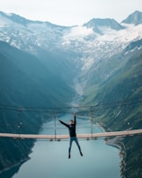 Adventurous rider crossing a wooden bridge over a sparkling river in the Patagonian wilderness