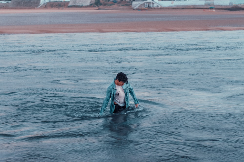 man in white shirt surfing on sea during daytime