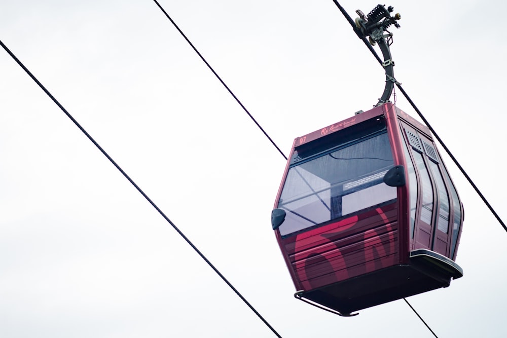 Téléphérique rouge sous un ciel blanc pendant la journée