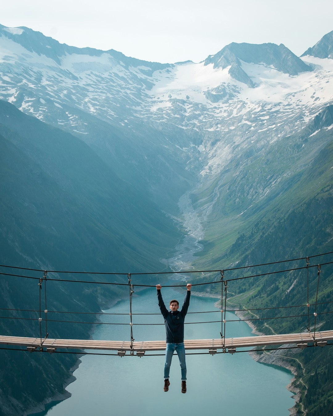 person in black jacket standing on bridge during daytime