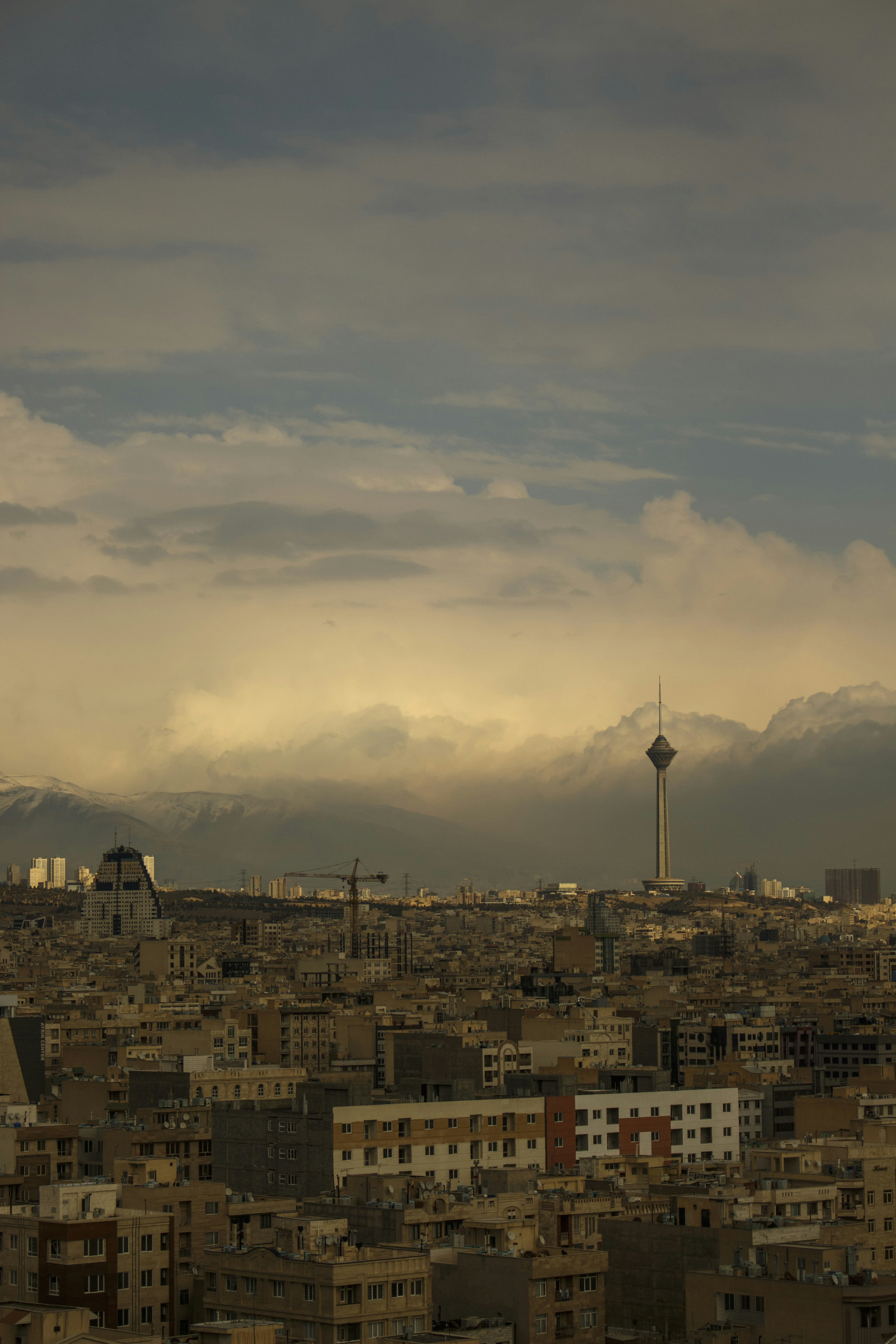 city with high rise buildings under white clouds during daytime