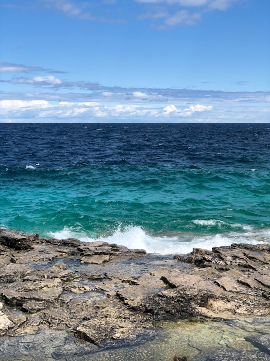 ocean waves crashing on rocky shore during daytime in Bruce Peninsula National Park Canada