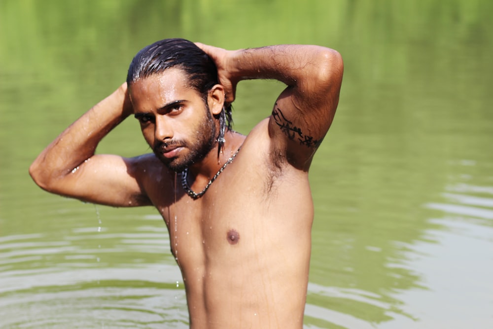 topless man in water during daytime