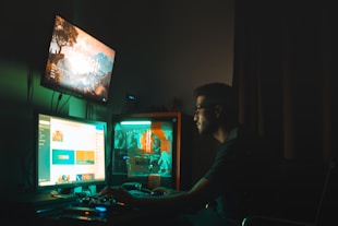 man in black shirt sitting in front of computer