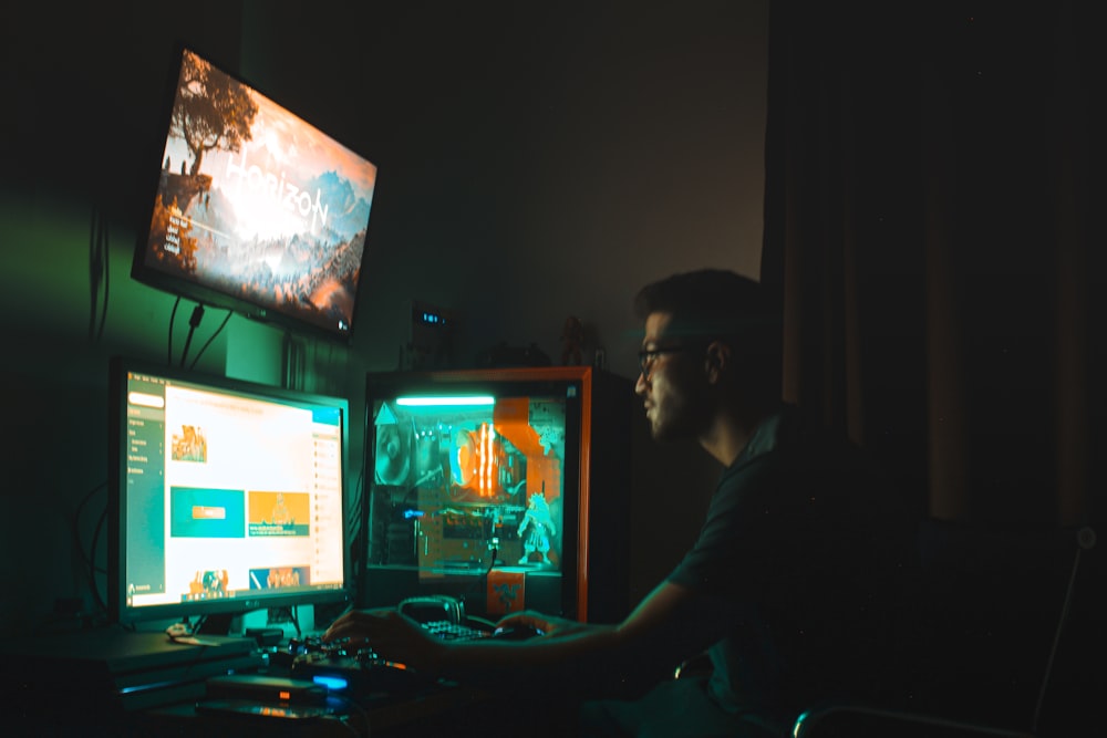 man in black shirt sitting in front of computer