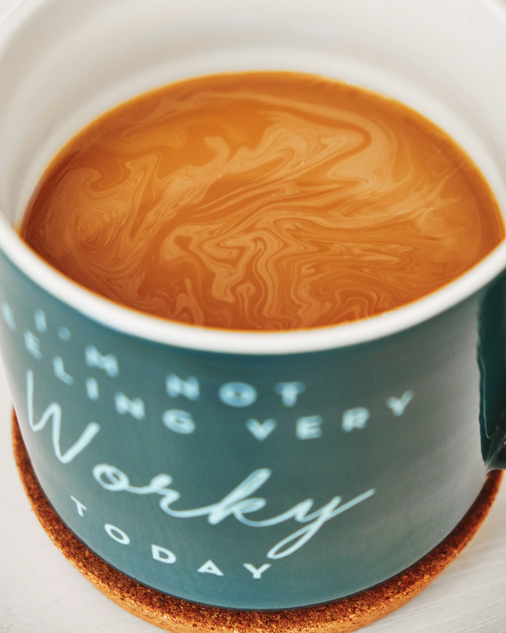 white and blue ceramic mug with brown liquid