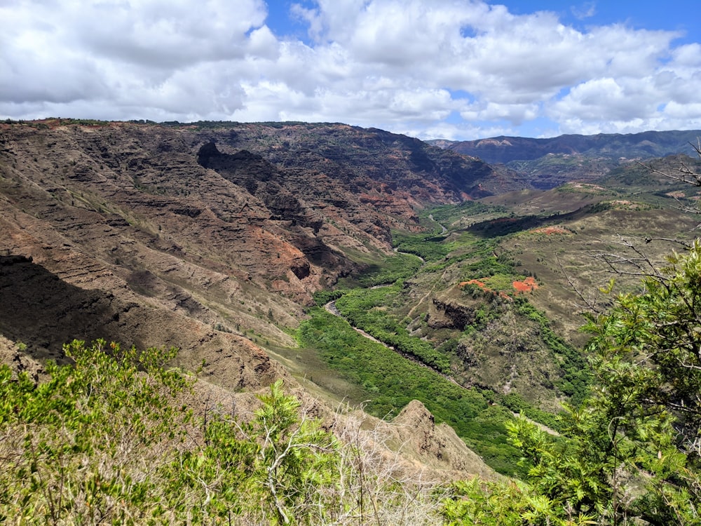 green and brown mountains under white clouds and blue sky during daytime