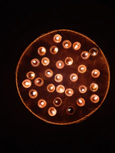 A beautifully arranged set of scented candles glowing softly on a wooden tray.
