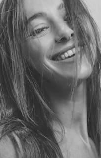 Portrait in black and white of a satisfied client smiling after a fresh haircut.