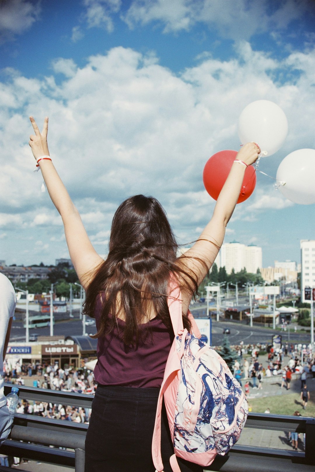 woman in purple shirt holding balloons