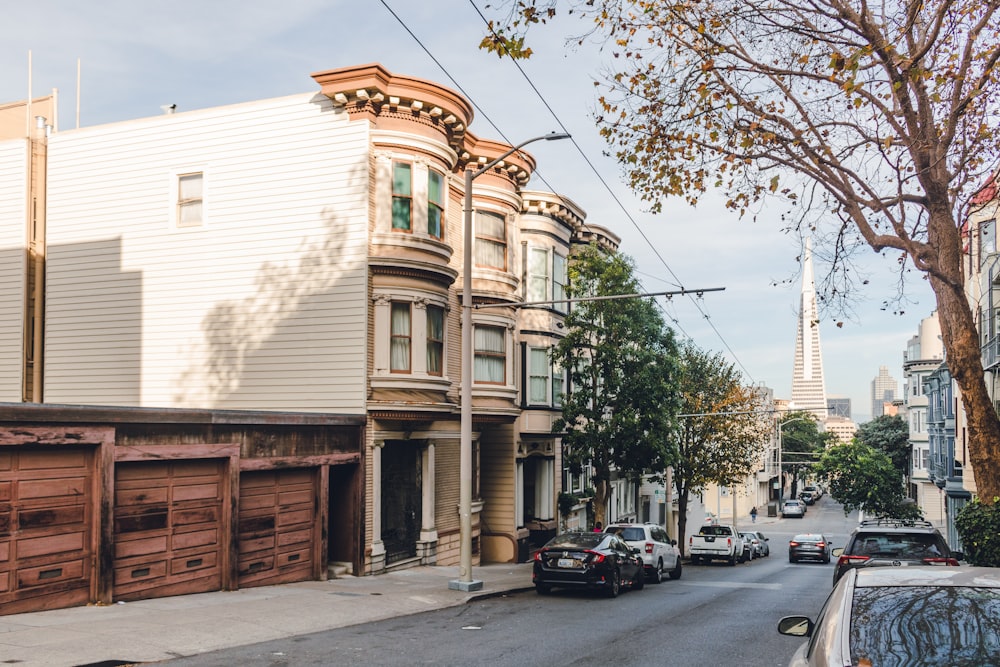 cars parked in front of white and brown building during daytime