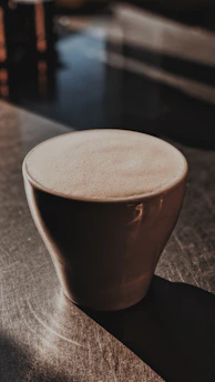 A warm cup of Colombian specialty coffee on a rustic wooden table with soft natural light highlighting its rich color.