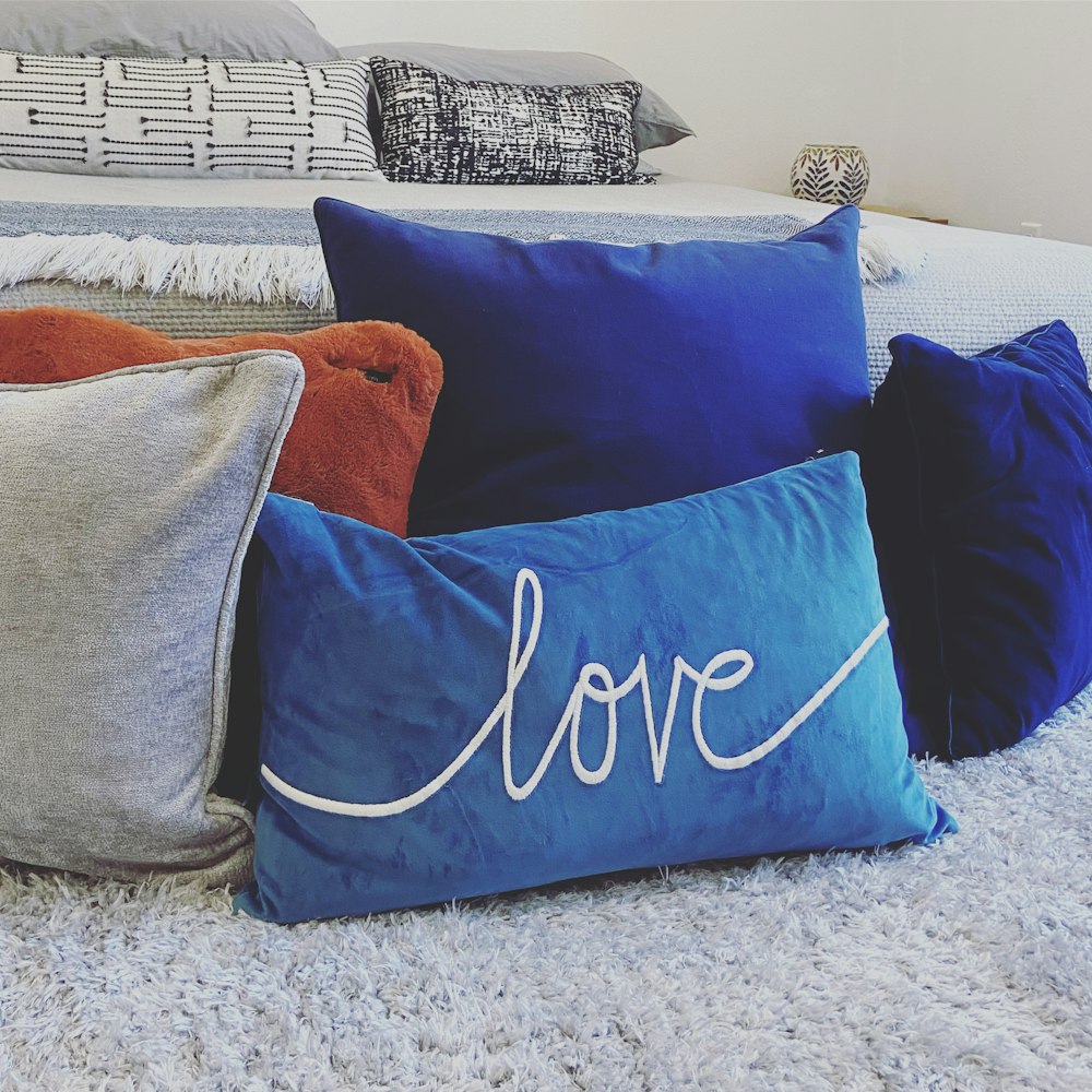 blue and white throw pillows on gray couch