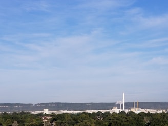 A modern factory with air filtration systems in operation, surrounded by clear blue skies.