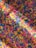 A vibrant assortment of colorful rice grains scattered in a mixed pattern. The colors include bright pink, yellow, and blue, creating a lively and playful mosaic effect.