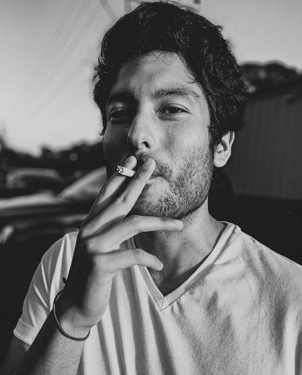 man in crew neck t-shirt smoking cigarette