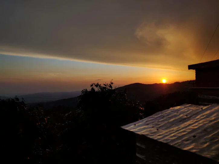 Sunset view over a cozy mountain lodge with warm glowing lights.