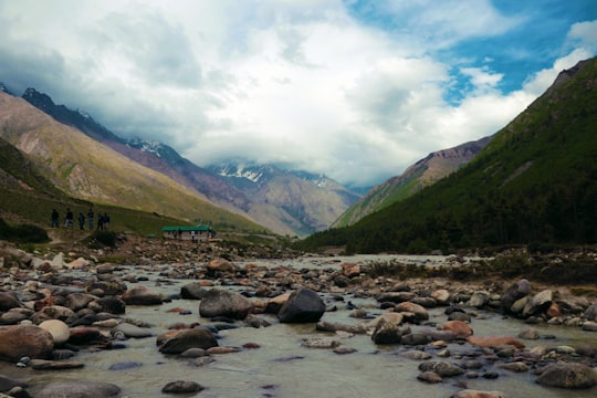 rocky river between mountains under cloudy sky during daytime in Chitkul India