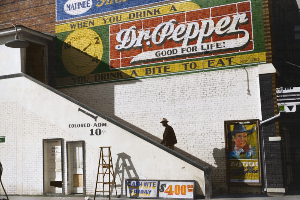 An African American man enters a movie theatre through the colored entrance