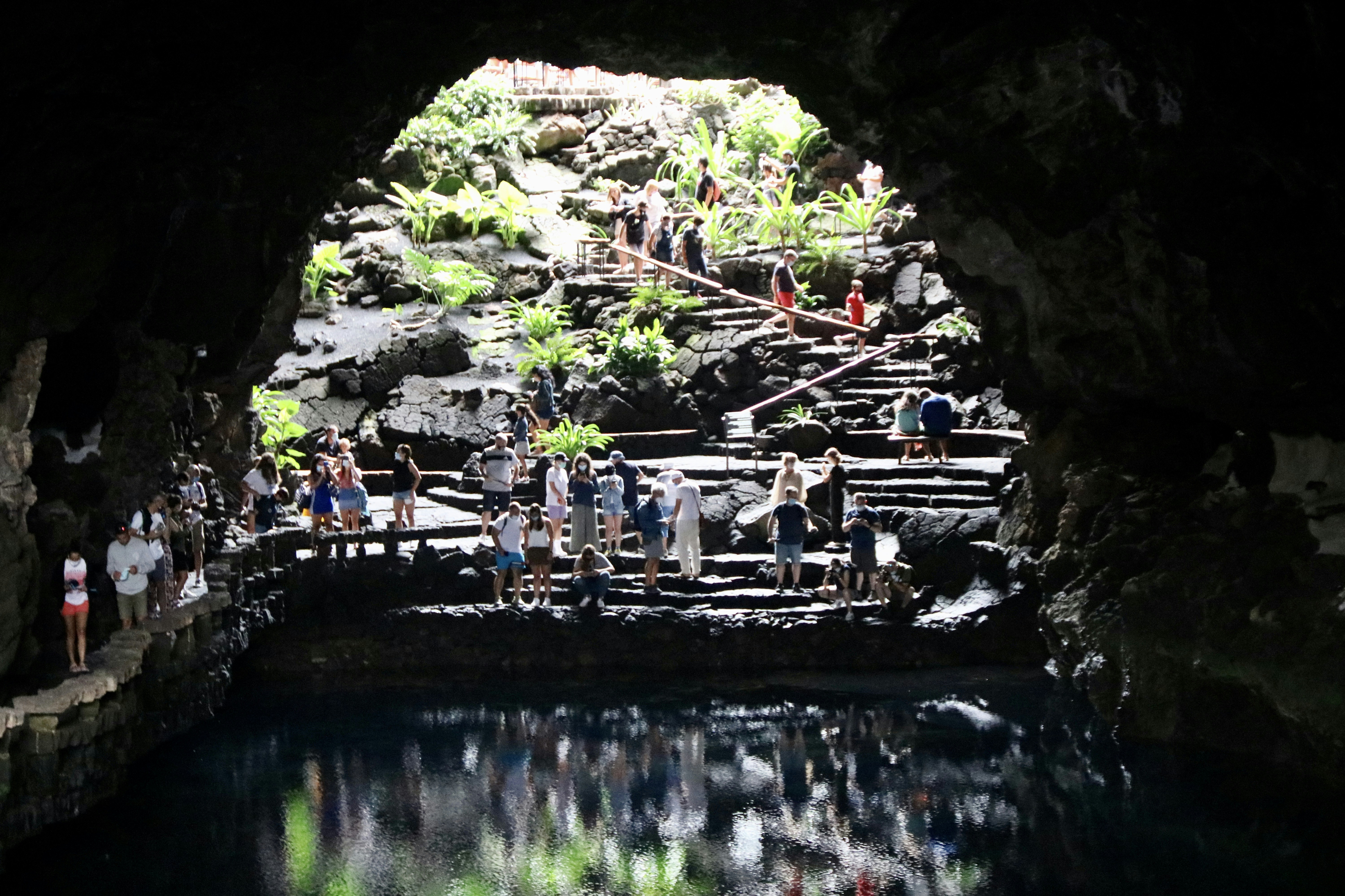 people sitting on bench near river during daytime