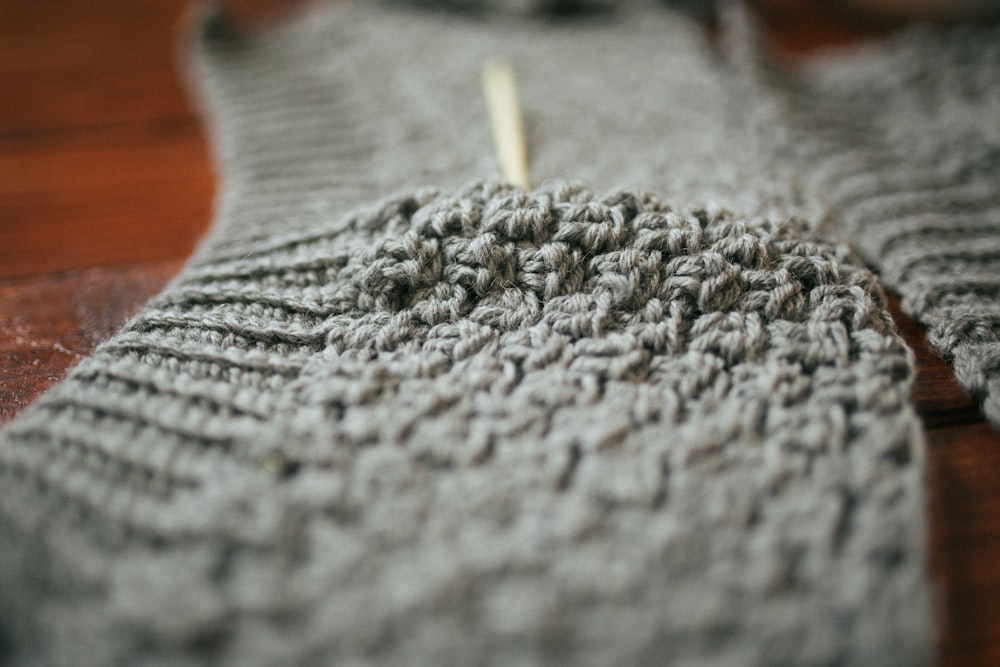 person holding gray knit textile