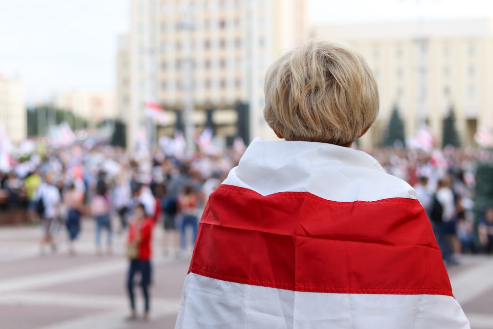 woman in white and red shirt standing on street during daytime