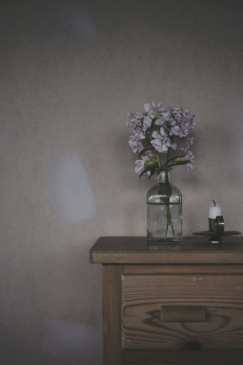 white flowers in clear glass vase on brown wooden table