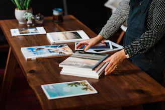 person in black and white long sleeve shirt holding white and blue book