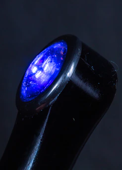 Close-up of a sleek black security volt with glowing blue accents on a dark background