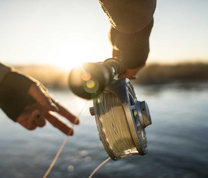 person holding fishing rod with reel