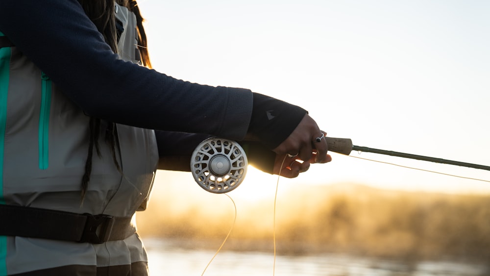 man in black long sleeve shirt holding black and silver fishing rod