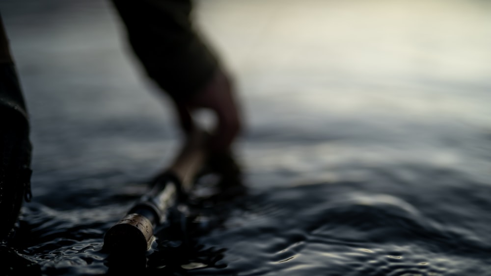 person in black pants and black shoes standing on water