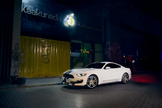 A happy person unlocking a sleek, modern car parked on a vibrant Delhi street.