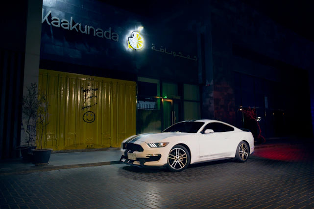 A happy person unlocking a sleek, modern car parked on a vibrant Delhi street.