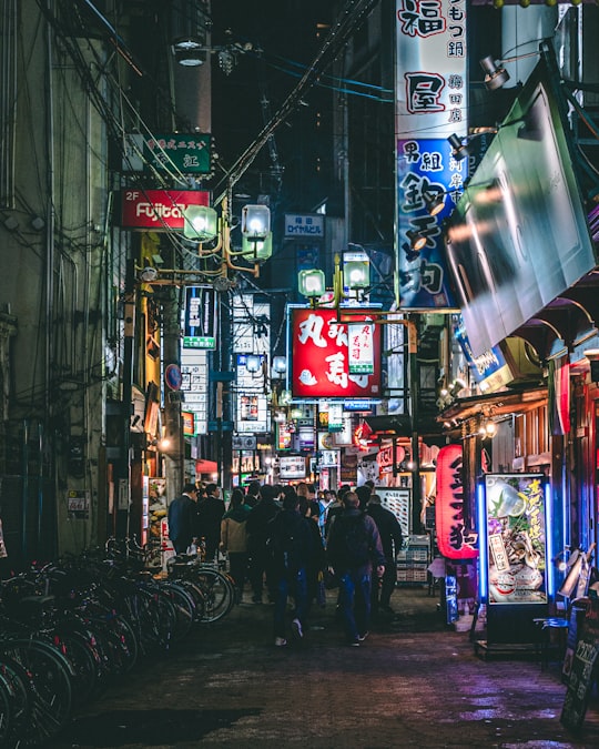 people walking on street during nighttime in Umeda Japan