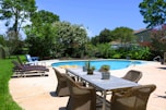 black metal table and chairs near swimming pool during daytime