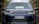 A close-up view of the front of a black Land Rover Discovery vehicle with a distinct grille and prominent headlights. The license plate displays the number 51H-320.62, and there are reflections visible on the windshield. The background consists of blurred trees, suggesting an outdoor setting.