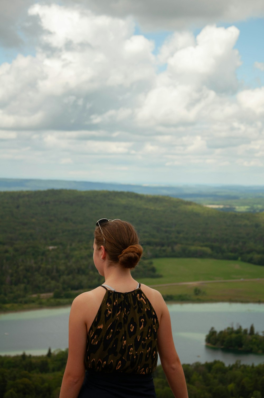 woman in black and brown leopard tank top looking at green mountains during daytime