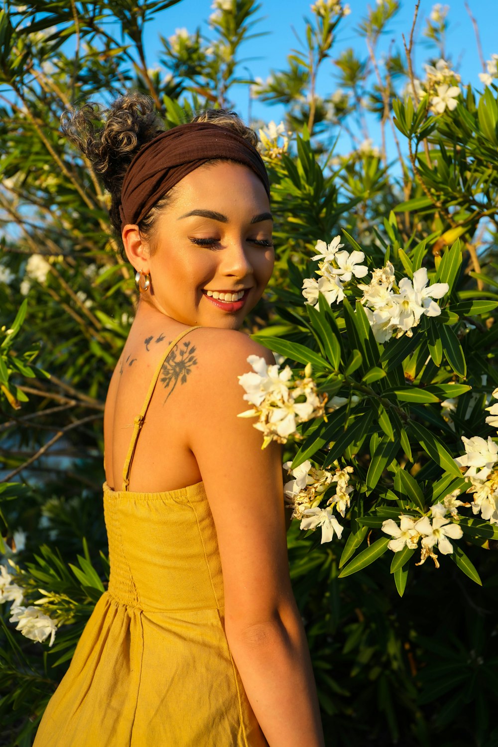 woman in yellow tube dress holding white flowers