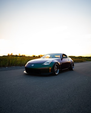 A sleek sports car photographed at sunset on an open road.