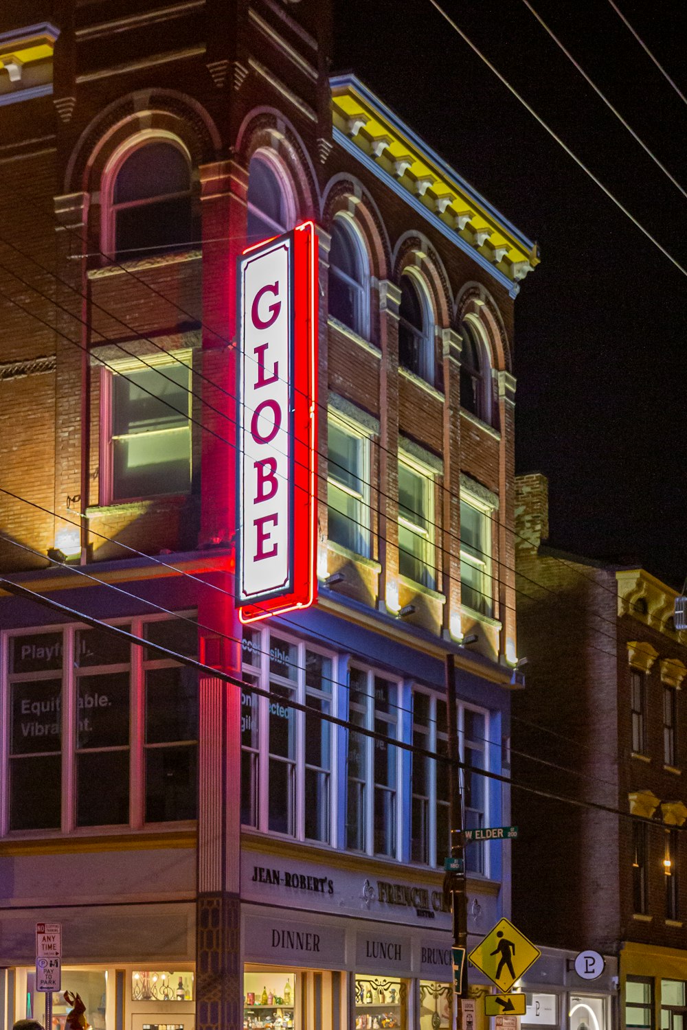 a tall building with a neon sign on the side of it