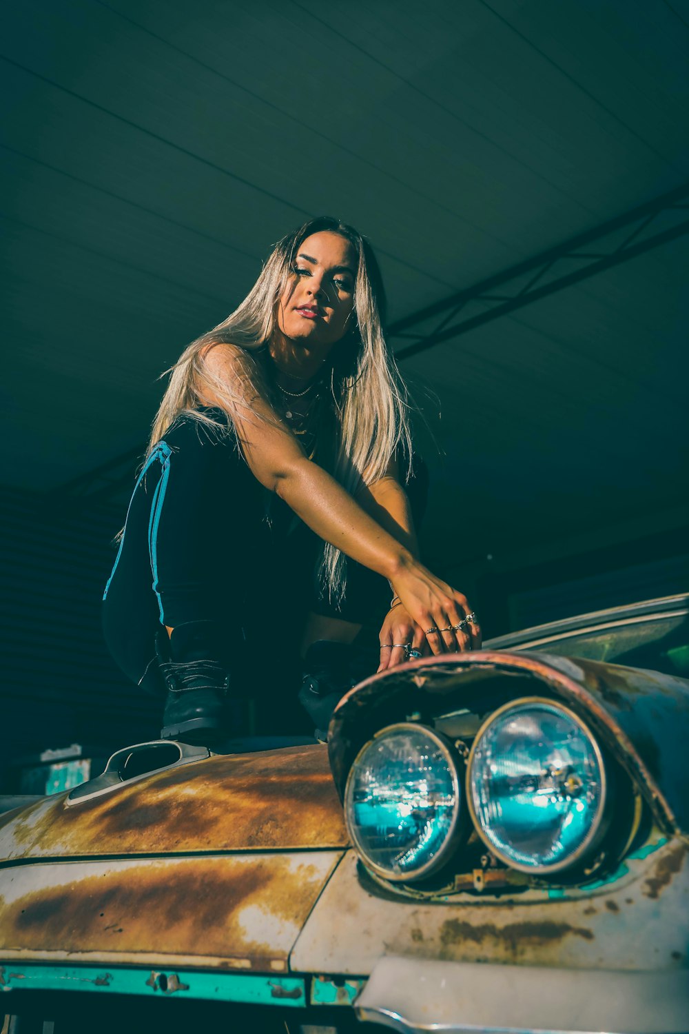 woman in black tank top leaning on car