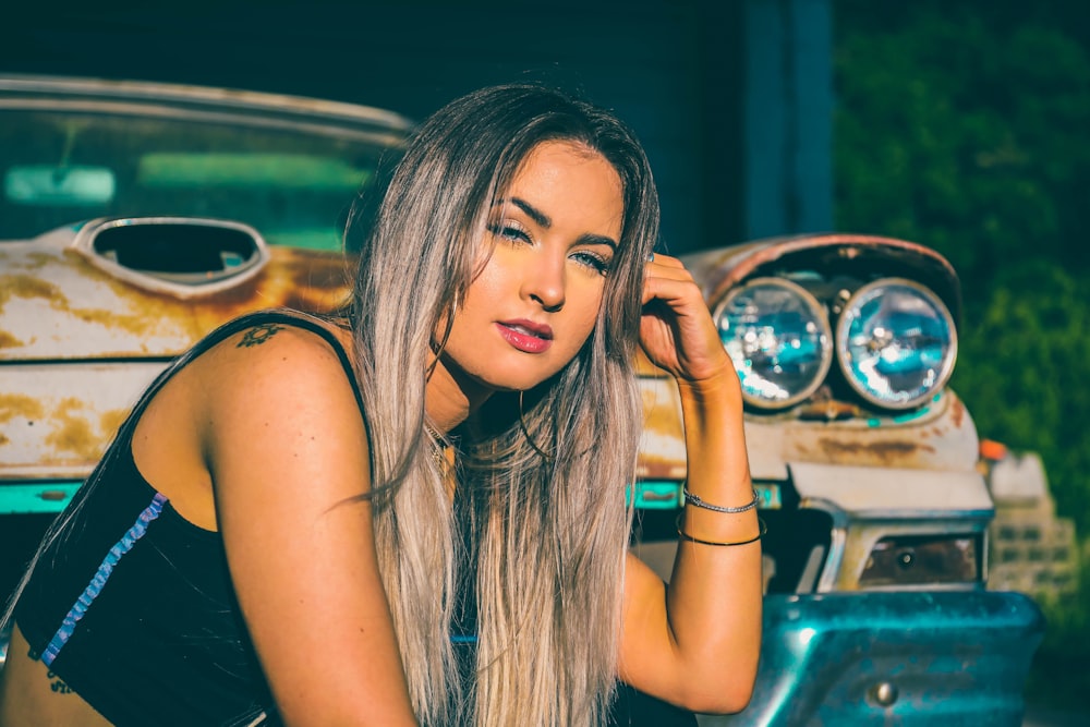 woman in black tank top sitting on car