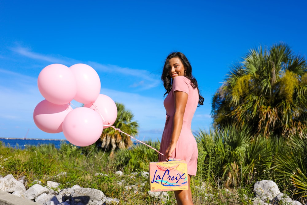 woman in white bikini holding balloons