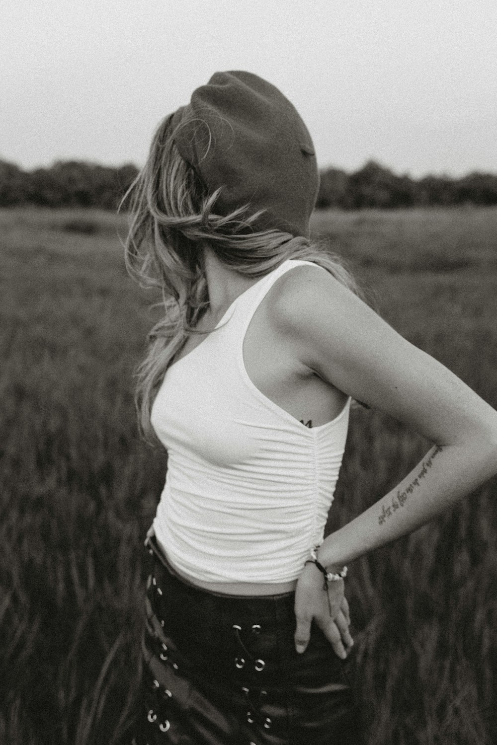 woman in white tank top and black shorts standing on grass field