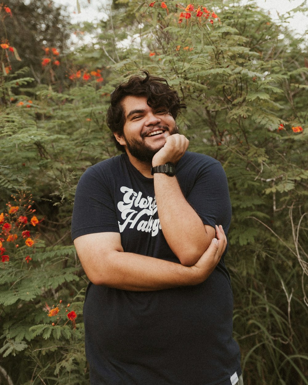 man in black crew neck t-shirt standing near green plants